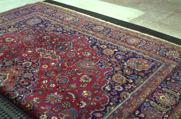 Rugs laid out for dust removal during the Oriental rug cleaning process